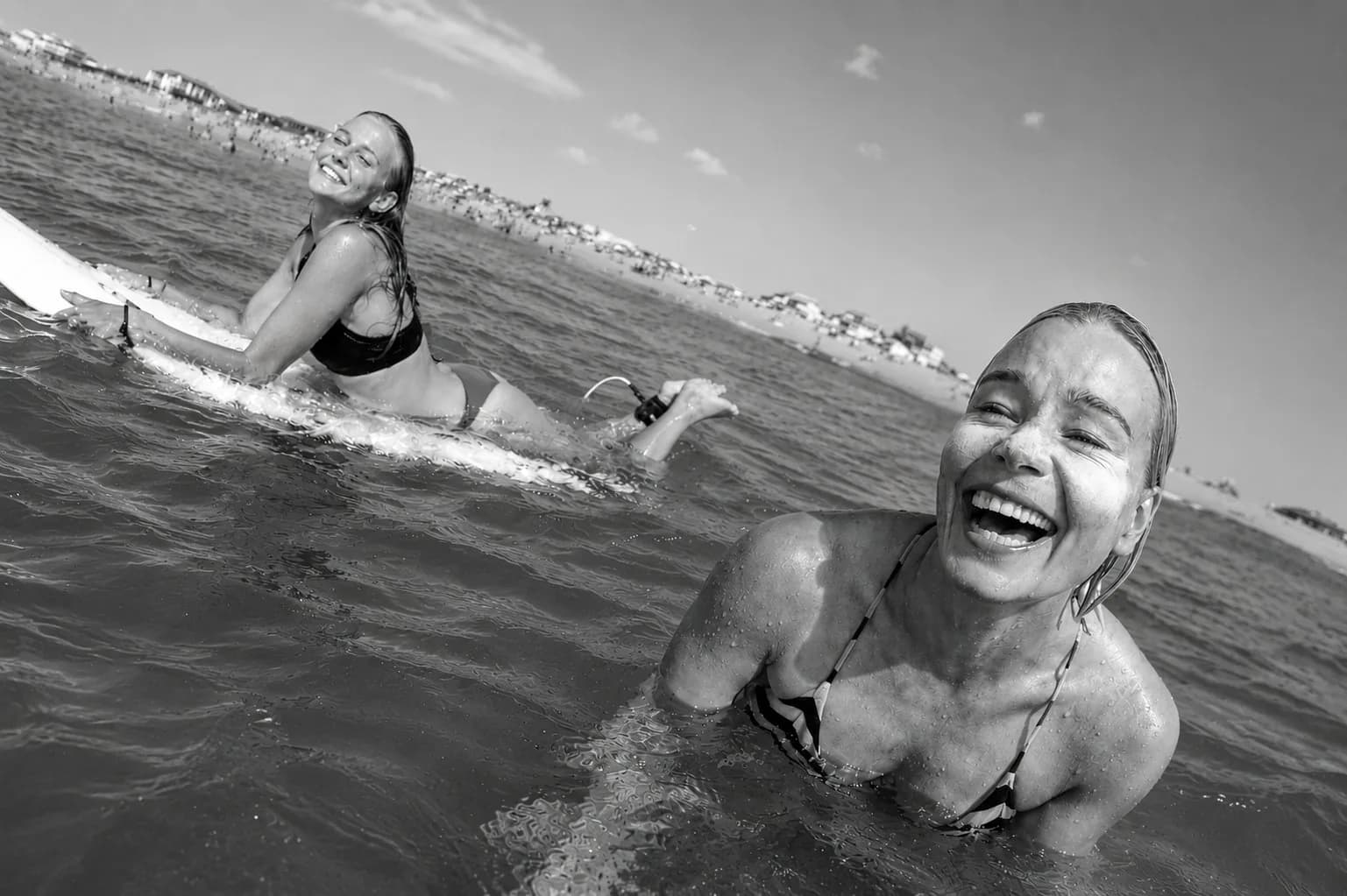 Two surfers laughing in the water at Hossegor
